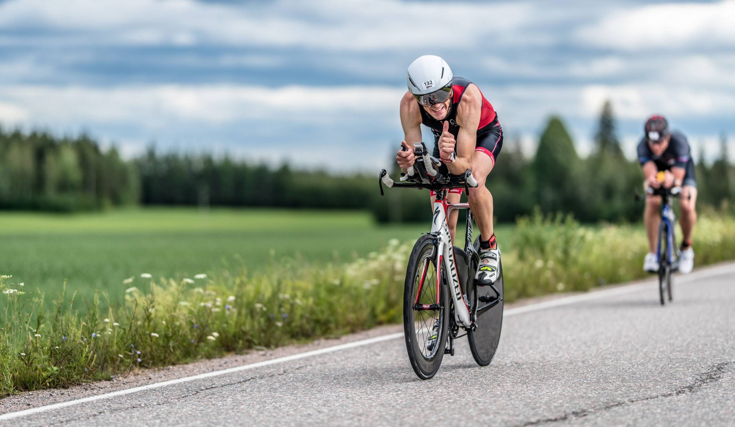 Man-cycling-on-a-bike-at-Ironman-triathlon-competition-in-Finland-scaled